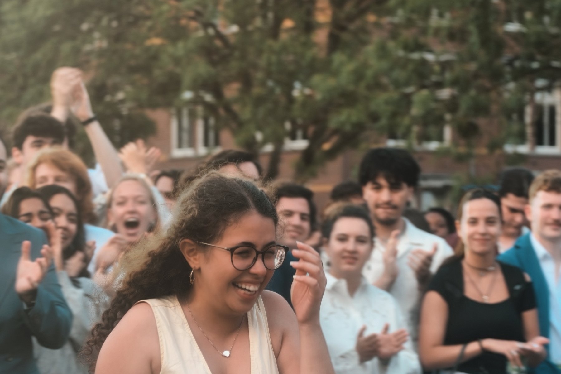 Members cheering and applauding in a crowd outdoors