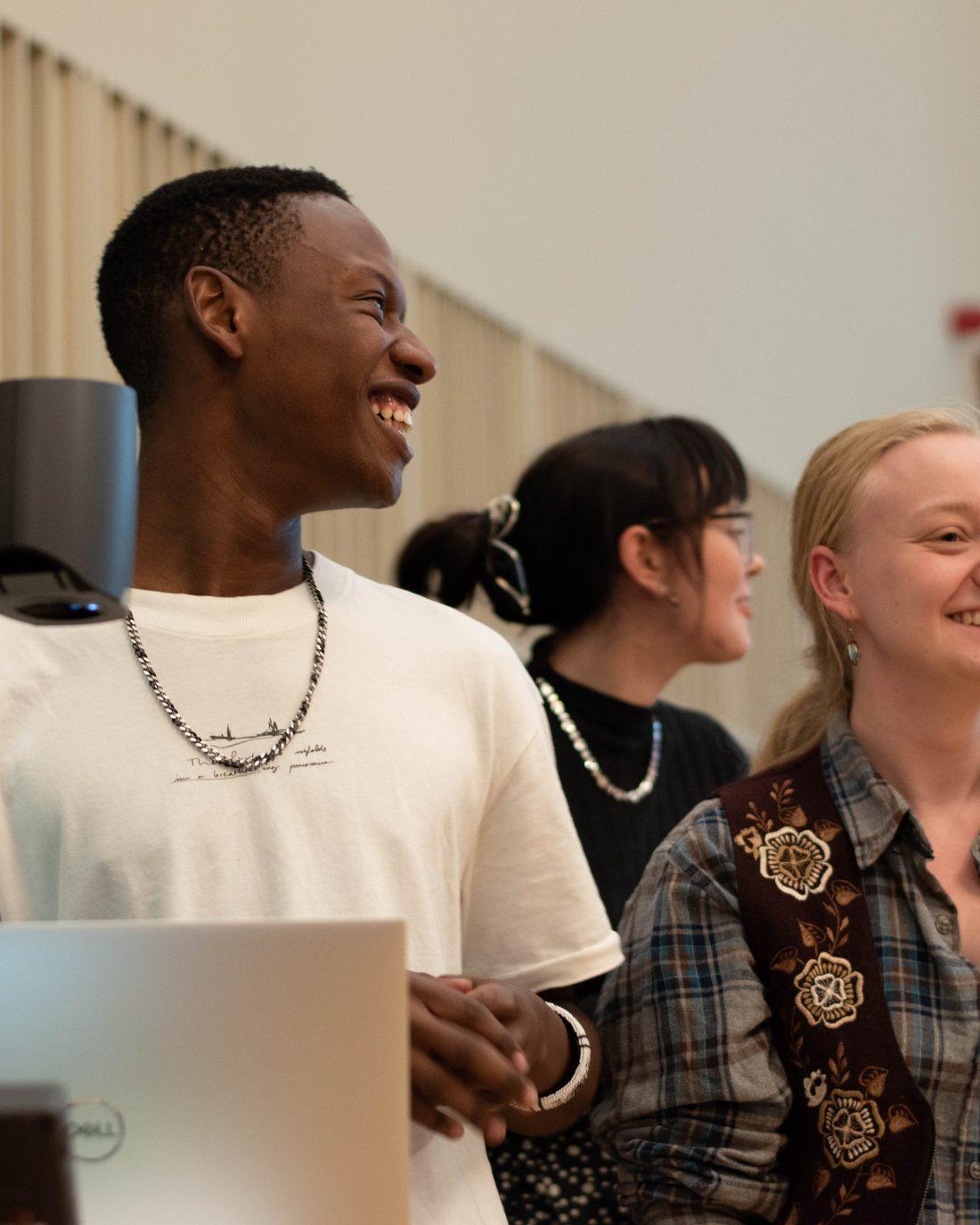 Members laughing behind a laptop at the Edinburgh Cup