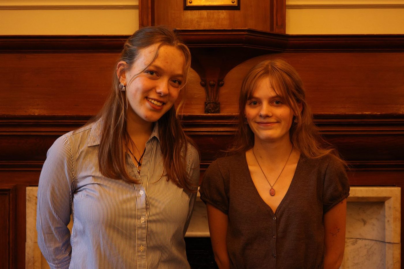 Two members talking in a wood-panelled room