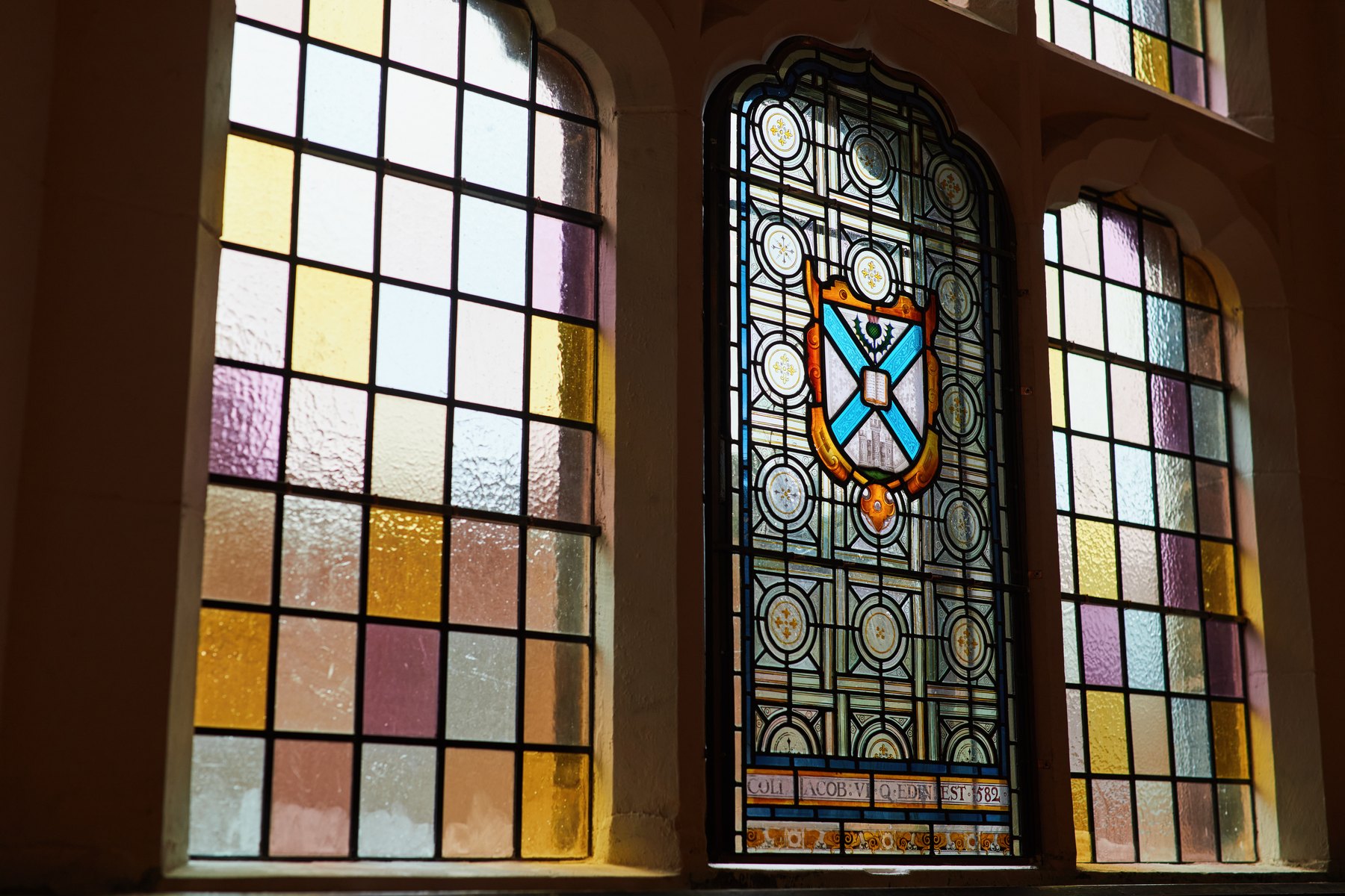 Stained glass windows in a panelled hall at Teviot